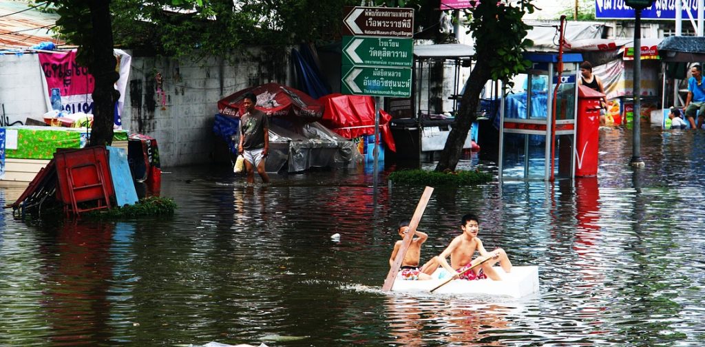 Boys in boat during flood in Bangkok